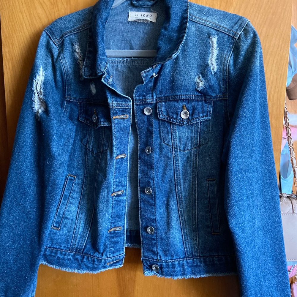 Blue Jean jacket with rips.